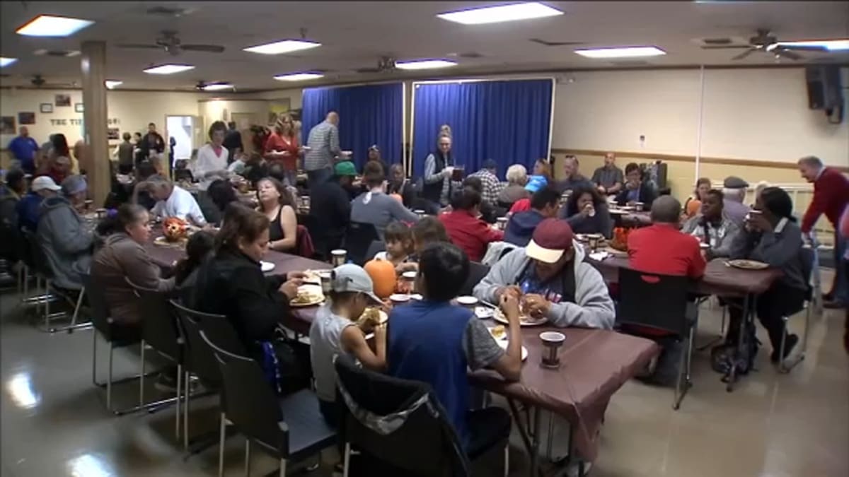 Volunteers serving meals and supporting homeless individuals at Fresno Mission community center