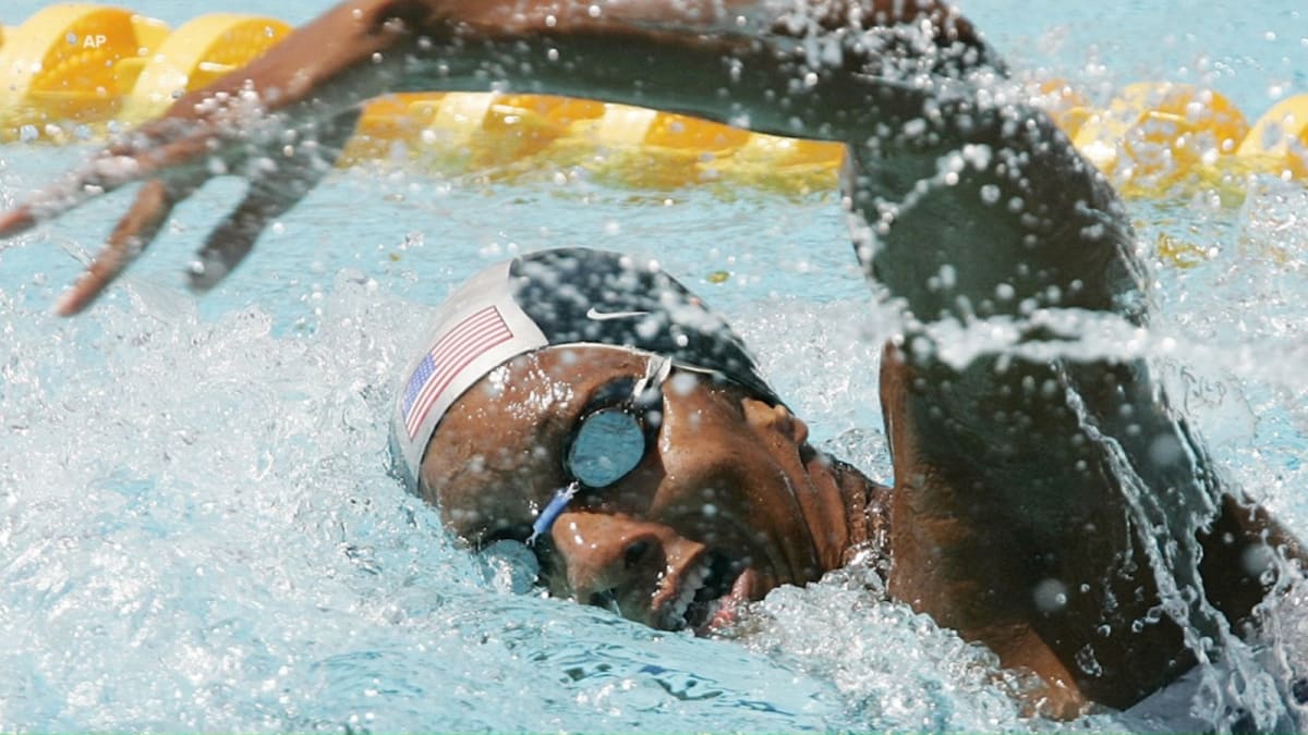 ** Olympic swimmer Maritza McClendon smiling in athletic gear, silver medal visible around neck