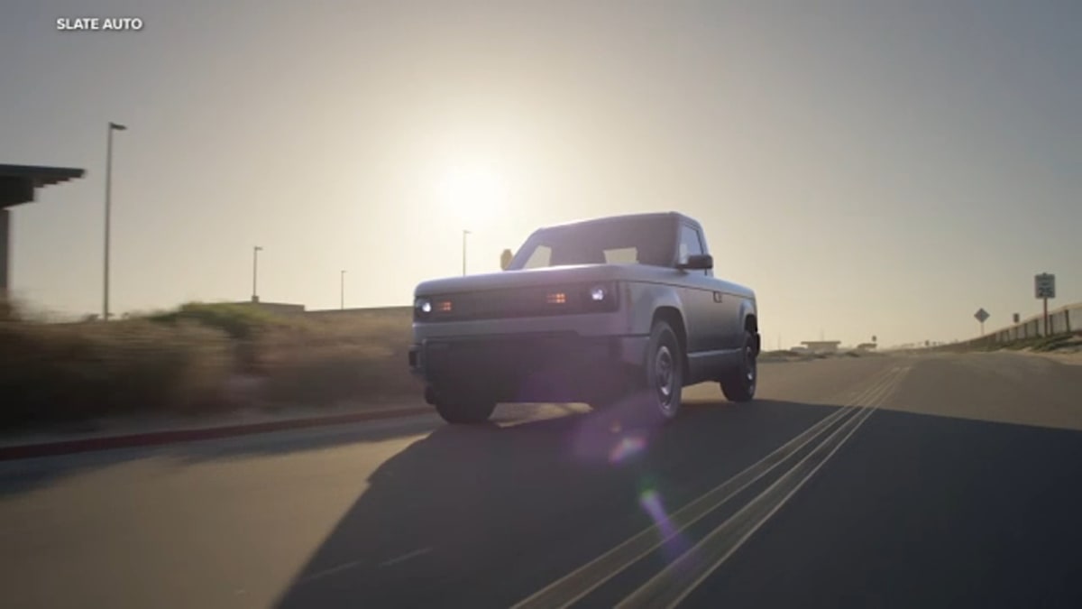 Slate electric pickup truck with gray composite panels and compact single-cab design parked outdoors