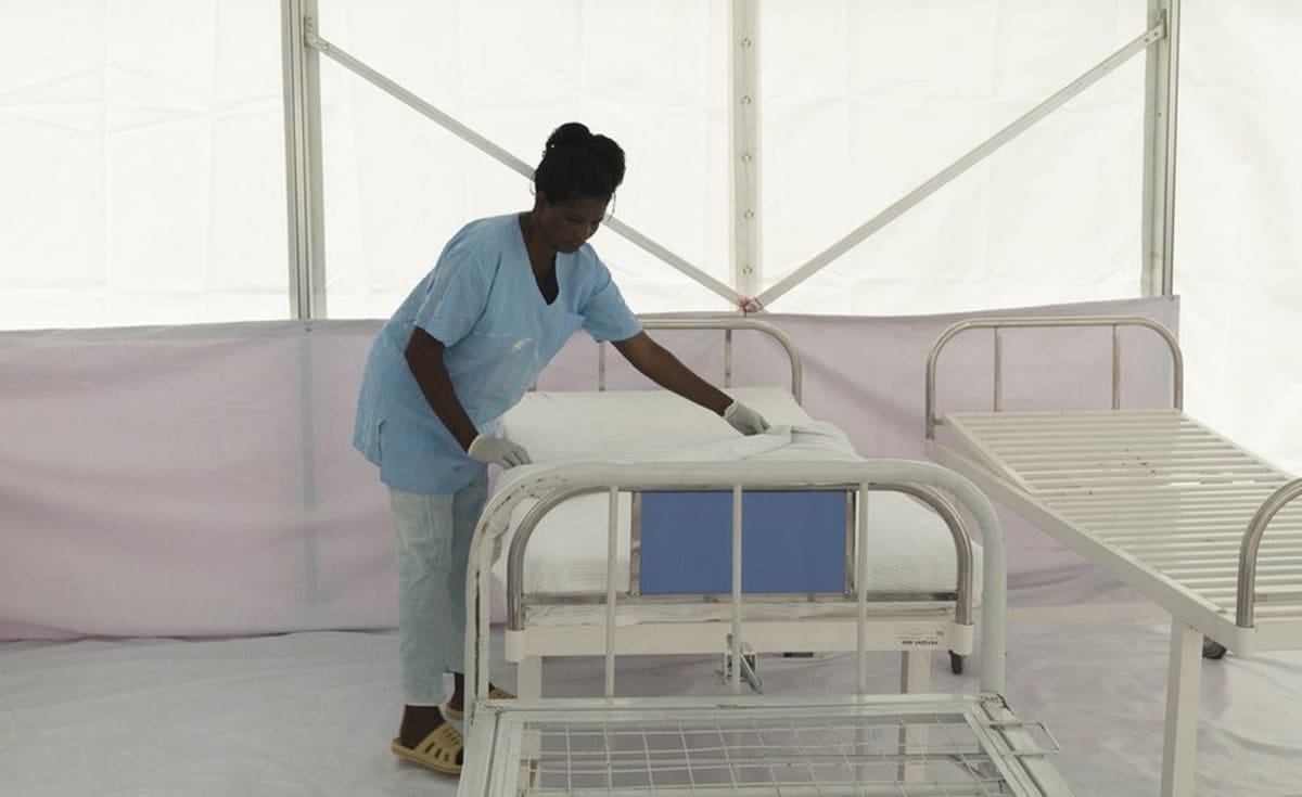Healthcare workers using computers and digital equipment in Ugandan medical facility with solar panels
