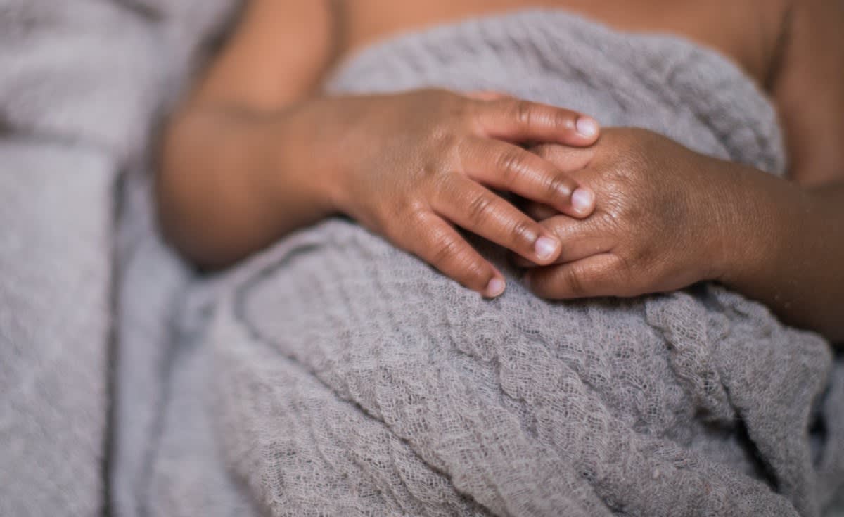 Tanzanian mother holding newborn baby at modern healthcare delivery center in East Africa