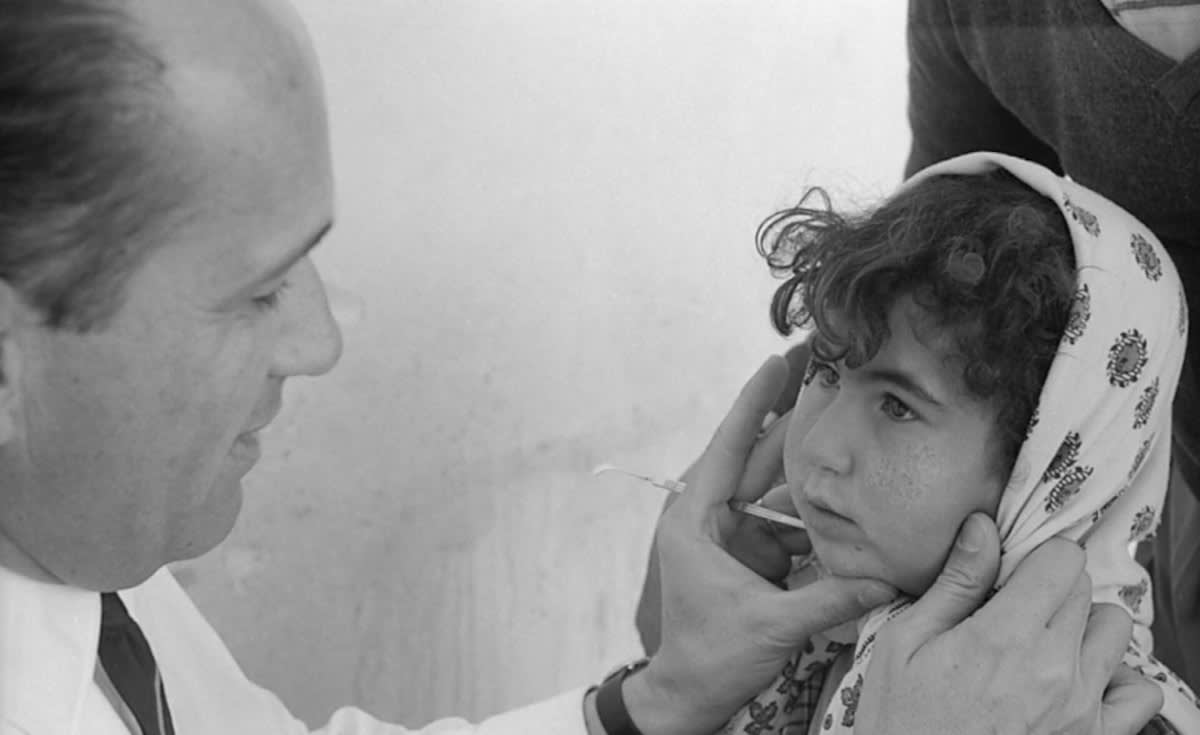 Healthcare workers examining patient's eyes in Tunisia medical facility celebrating trachoma elimination