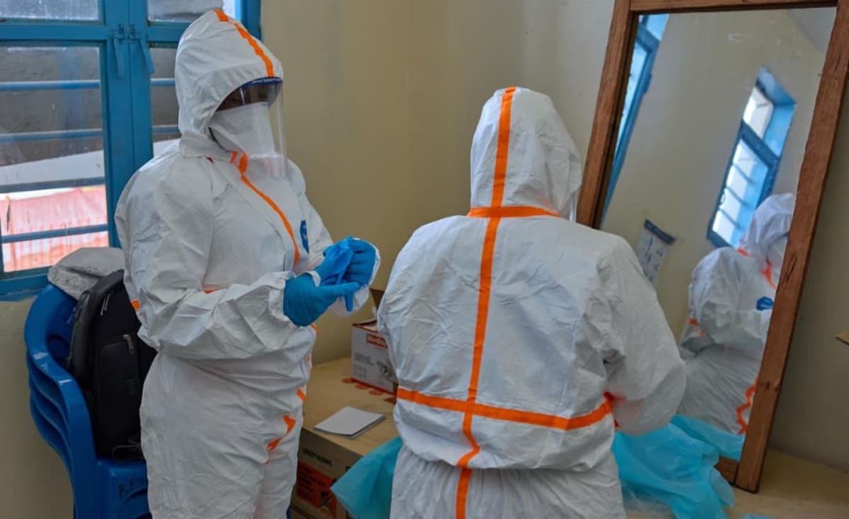 Healthcare workers in protective gear treating patients at Ebola treatment center in eastern DR Congo