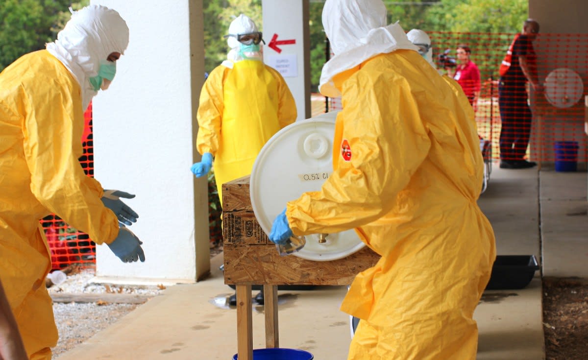 Medical workers in protective gear preparing experimental Ebola treatments for shipment to Congo