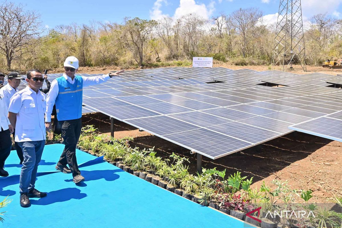 Solar panels stretching across Indonesian landscape with traditional Balinese temple in background
