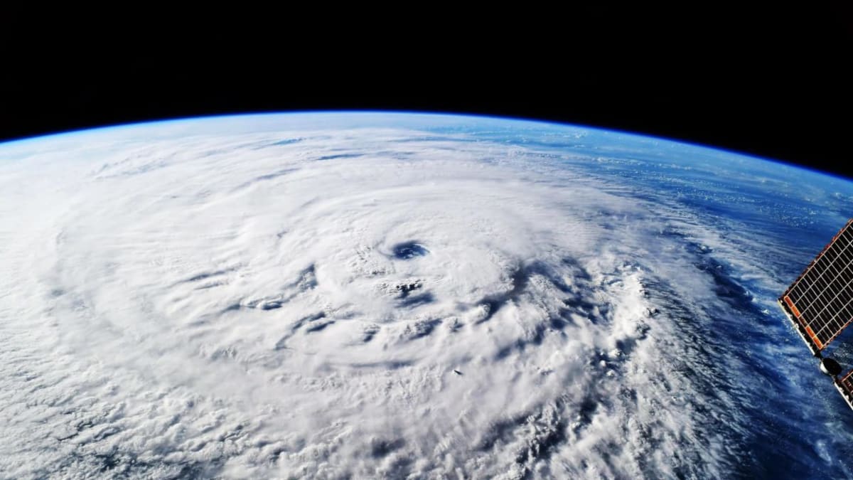 Satellite view of hurricane system swirling over Caribbean waters with AI prediction overlay