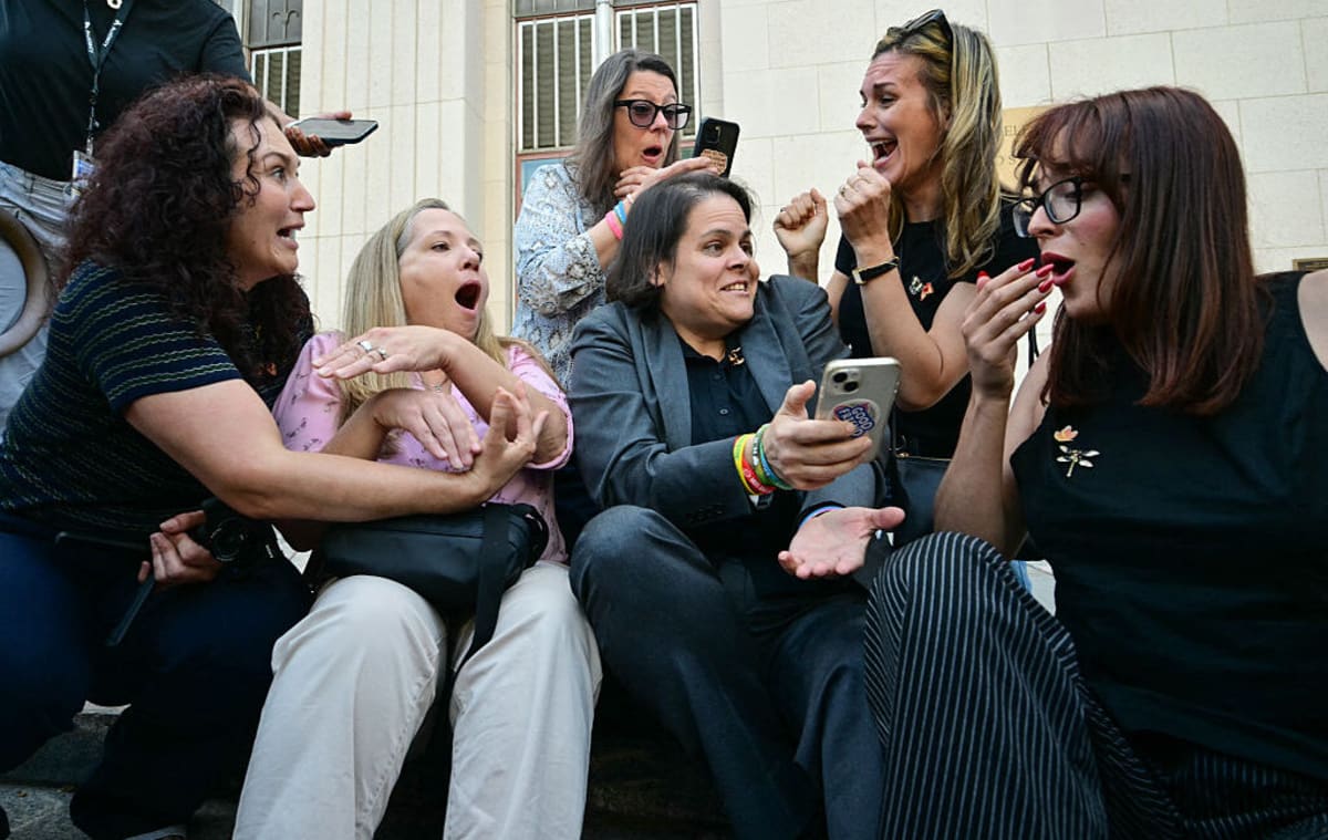 Young woman looking at smartphone screen in dark room, representing social media addiction impact
