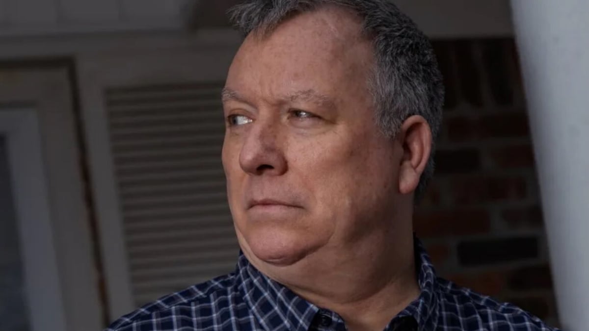 Man using smartphone with Facebook app, representing social media free speech rights
