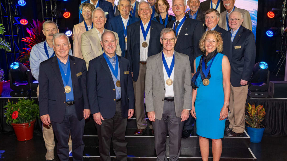 Tom Akers and Joe Tanner stand surrounded by fellow astronauts at Kennedy Space Center
