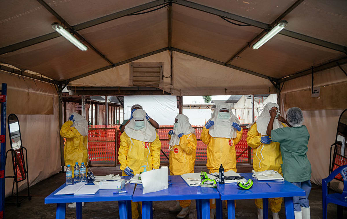 Healthcare workers in protective gear conducting Ebola testing at medical facility in Democratic Republic of Congo