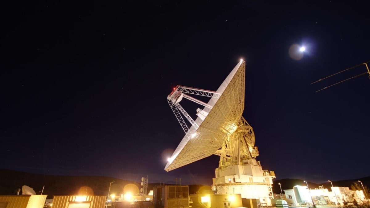NASA's massive deep space antenna dish pointing skyward tracking spacecraft near the Moon