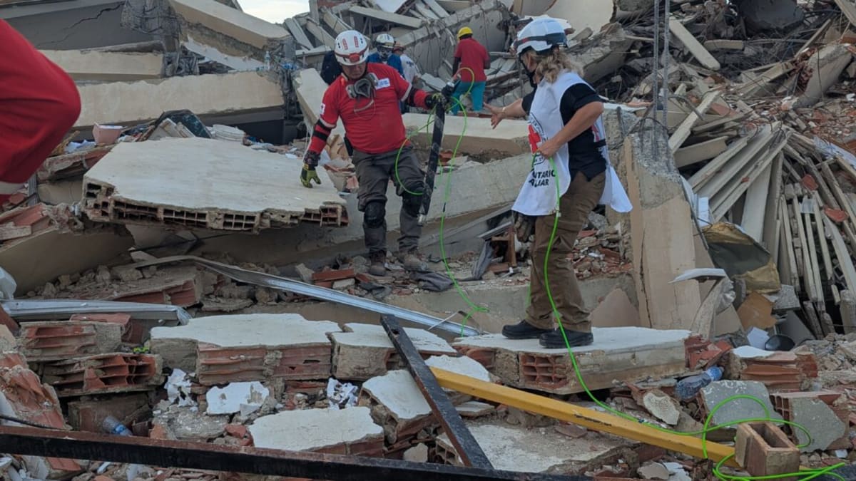 Snake-like robot with camera navigating through concrete rubble and debris in Venezuela earthquake zone