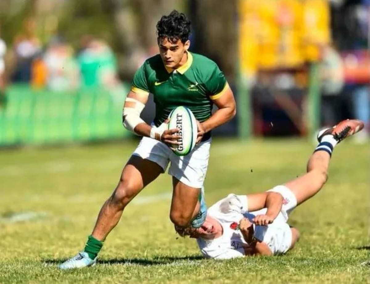 Young South African rugby players in Junior Springboks uniform celebrating together on field