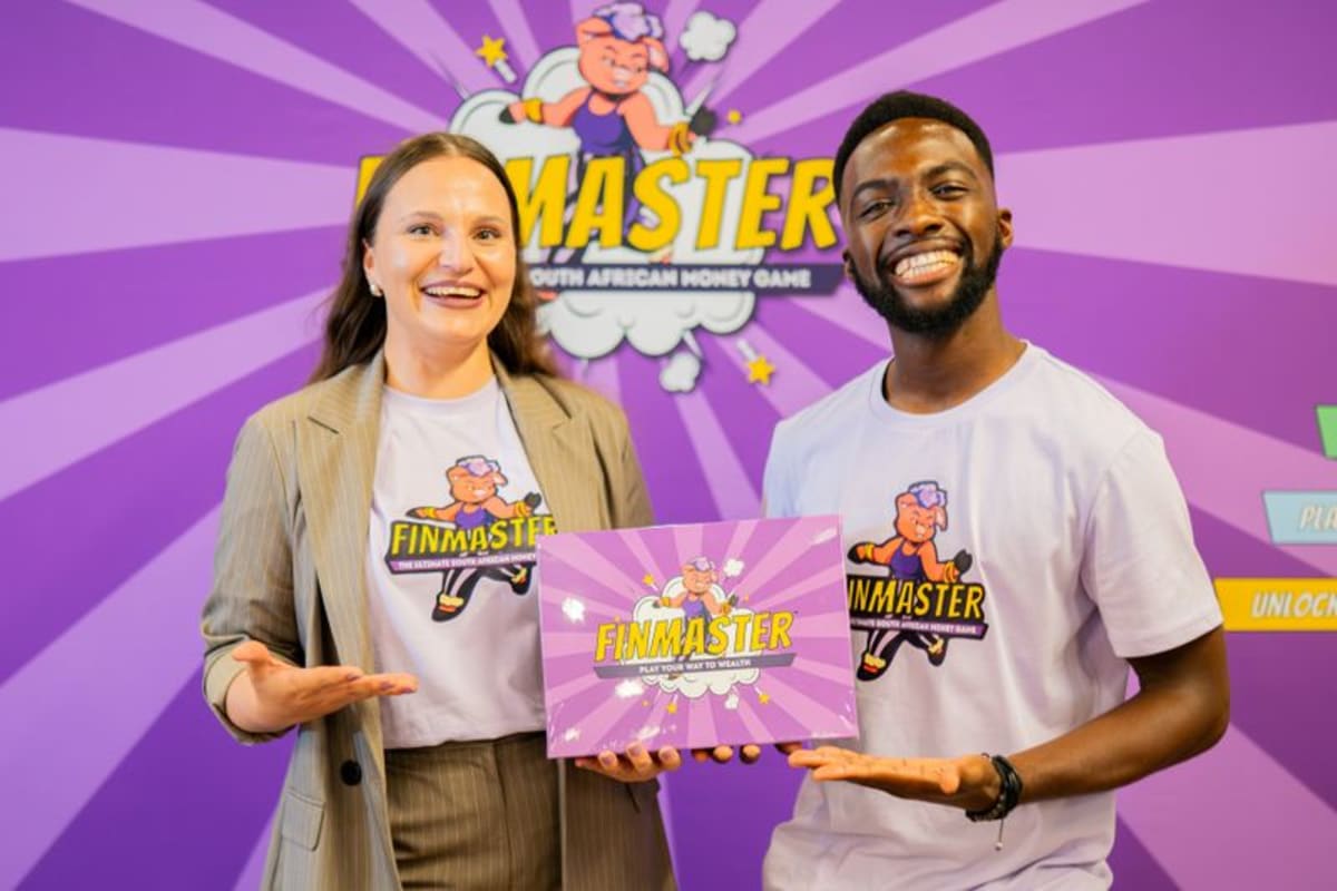 Danei Rall and Elijah Djan holding their FinMaster financial literacy board game