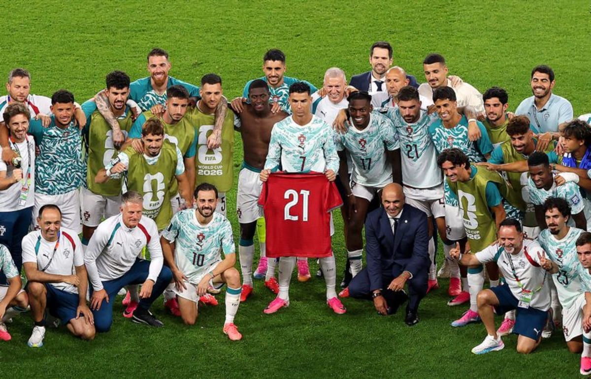 ** Cristiano Ronaldo holds Diogo Jota's number 21 jersey surrounded by Portugal teammates celebrating