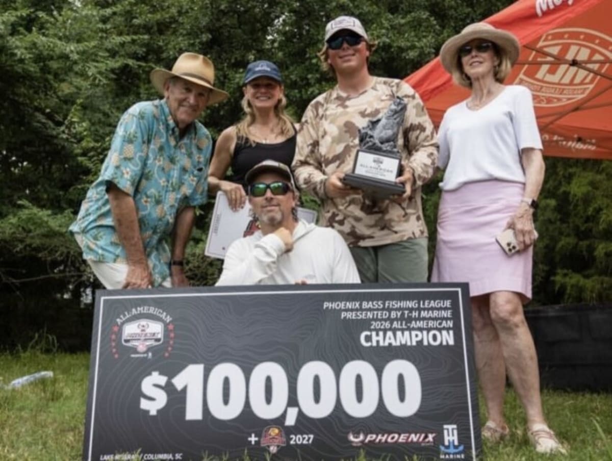 Young angler Jack Story holding trophy and oversized check at Lake Murray bass fishing tournament