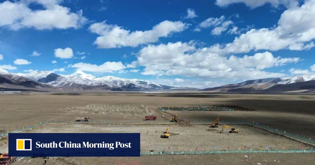 Aerial view of massive parabolic solar mirror arrays on Tibet's high-altitude plateau landscape