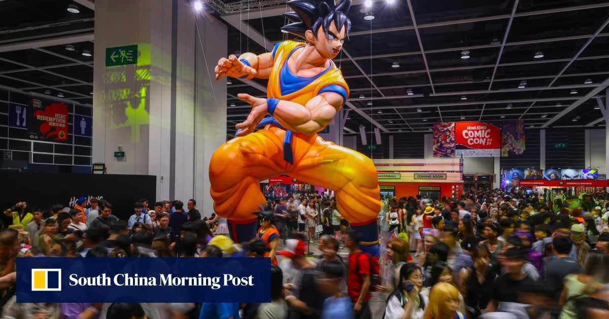 Crowded convention floor at Hong Kong Comic Con with giant anime character statues and cosplayers