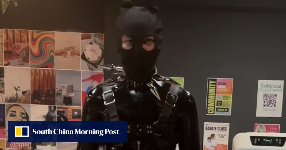 Cosplayer in black latex catsuit with helmet at Kuala Lumpur convention center