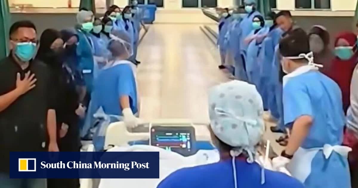 Hospital staff line corridor in respectful tribute during organ donor honor walk ceremony