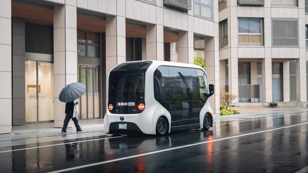 White autonomous Toyota e-Palette bus traveling through modern street in Woven City Japan
