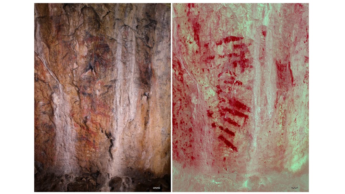 Ancient red horizontal lines painted on dark cave wall in Bacon Hole, Wales