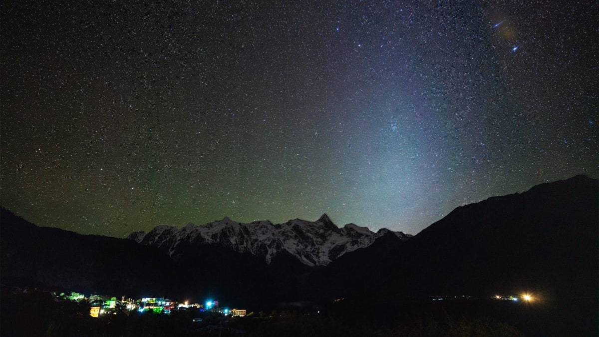 Broad cone of soft glowing light extending upward from eastern horizon before dawn