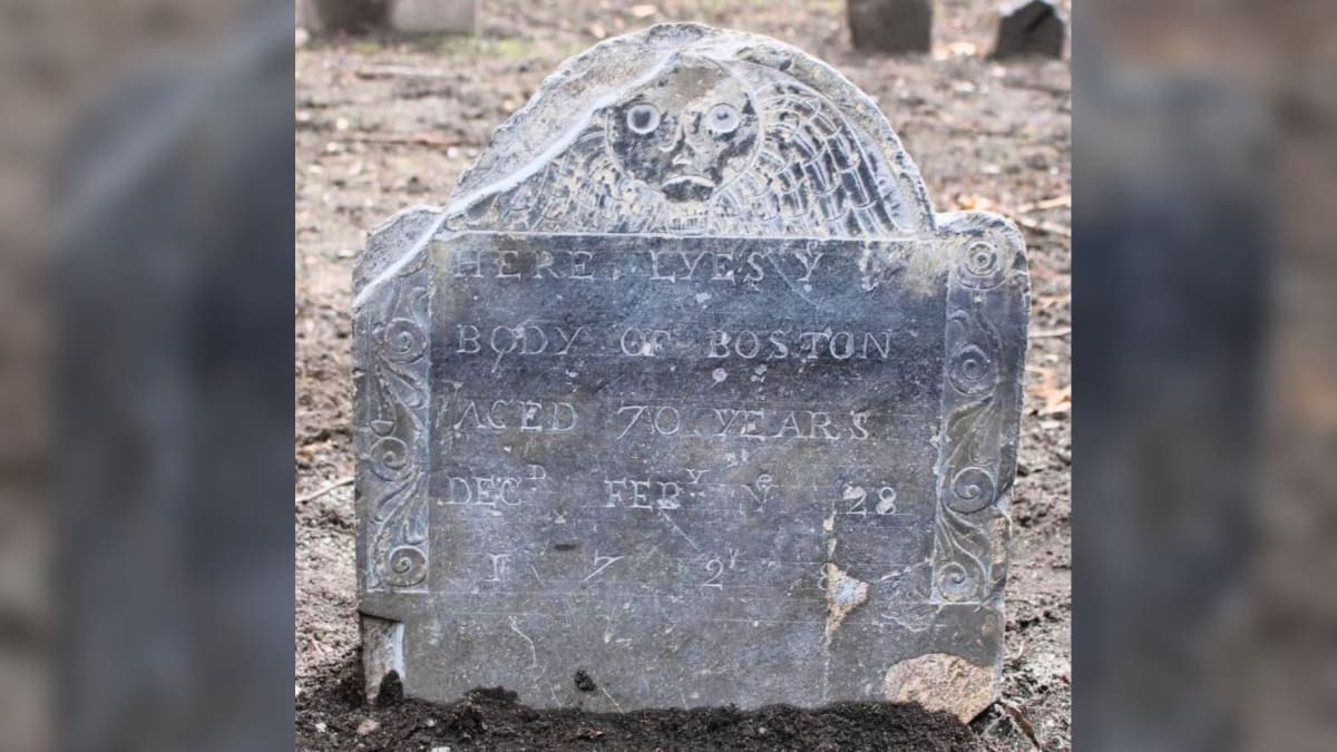 Weathered 1729 gravestone with death's head symbol marking Boston's burial in colonial cemetery