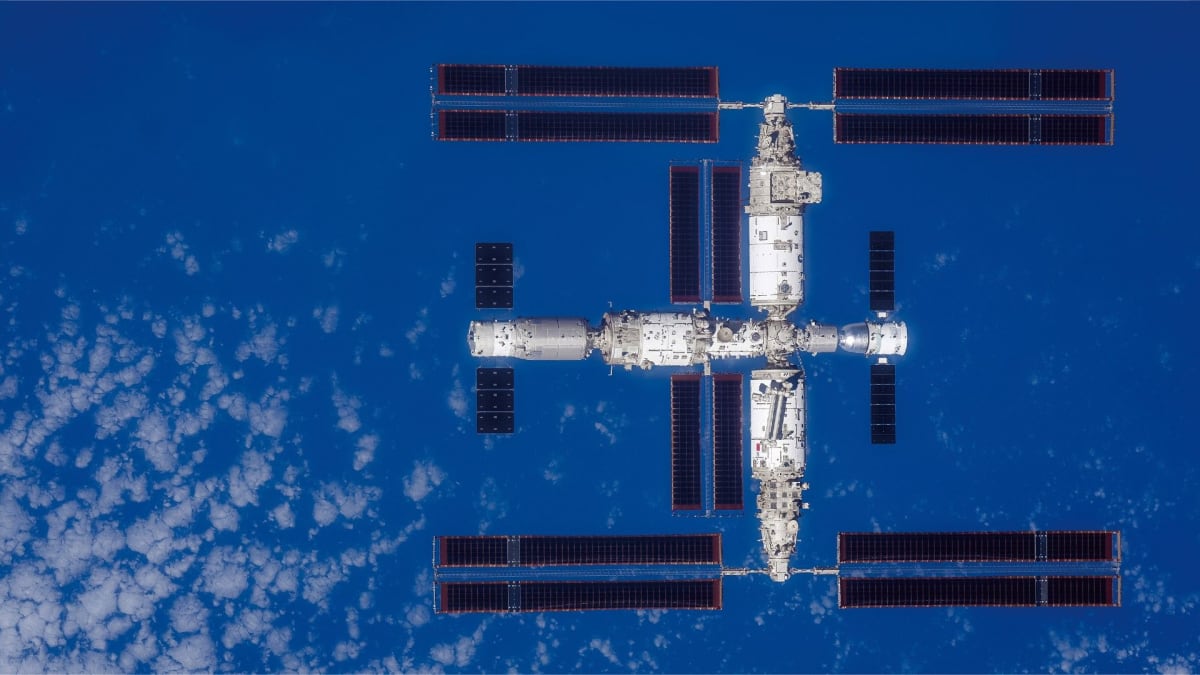 China's Tiangong space station orbiting above Earth with solar panels extended against black space