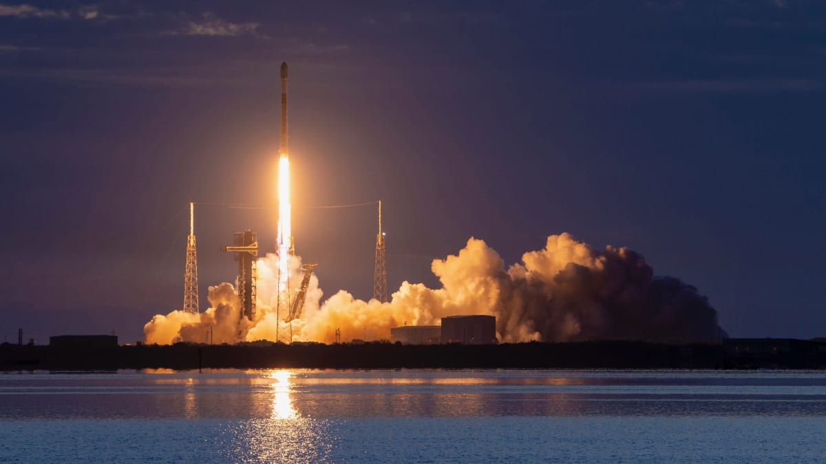 SpaceX Falcon 9 rocket launching from Cape Canaveral with bright flames illuminating night sky