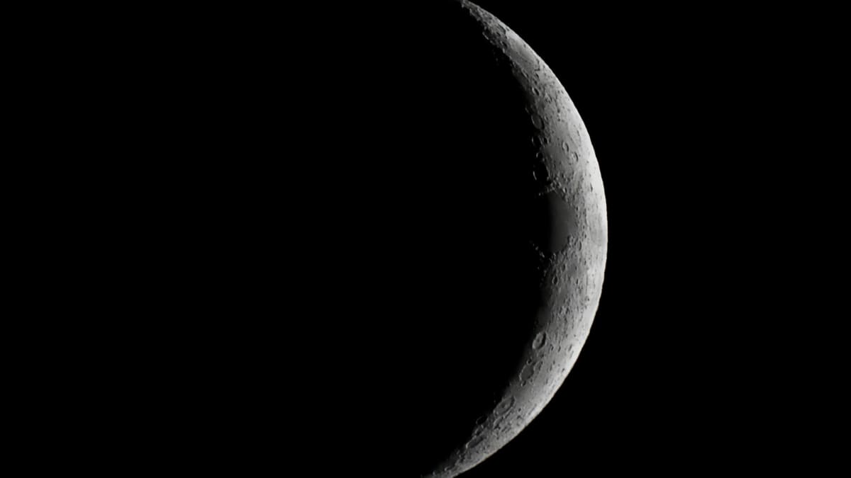 View of Earth's moon during waxing crescent phase against black space background