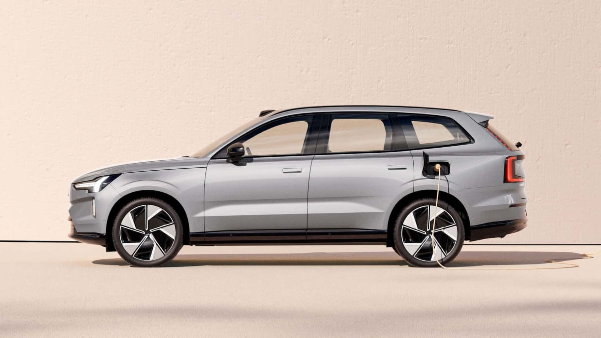 Silver Volvo EX60 electric SUV plugged into charging station without driver present