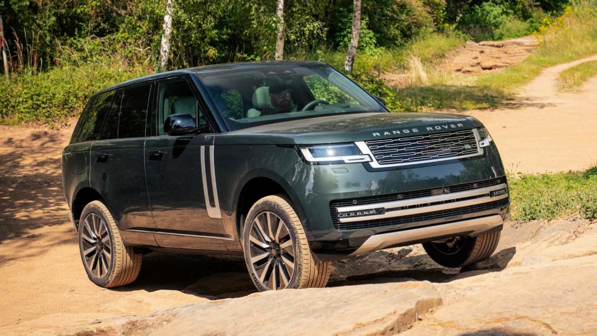 Luxury Range Rover electric SUV driving on rugged off-road terrain in England