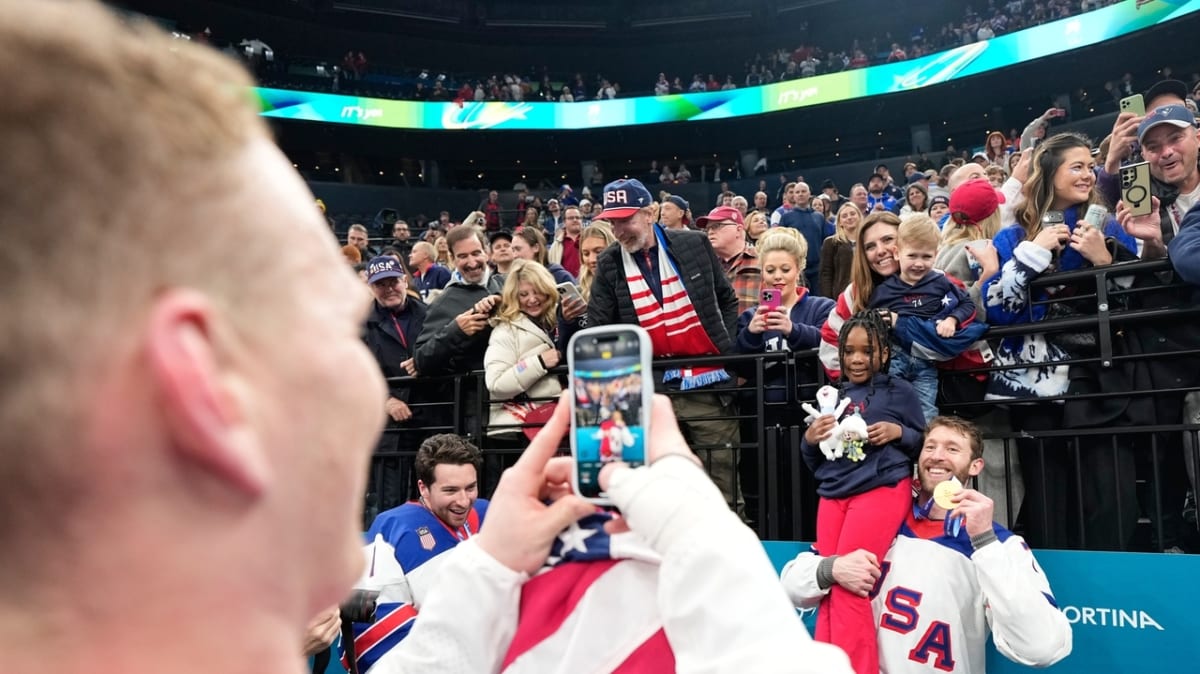 Jaccob Slavin holding Olympic gold medal wearing Team USA jersey in Milan