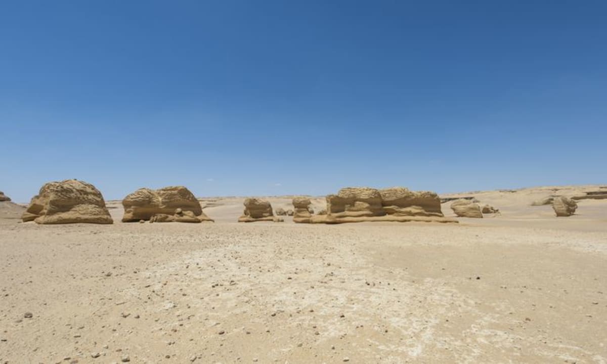 Sandstone rock formations rising from Egypt's Western Desert under clear skies