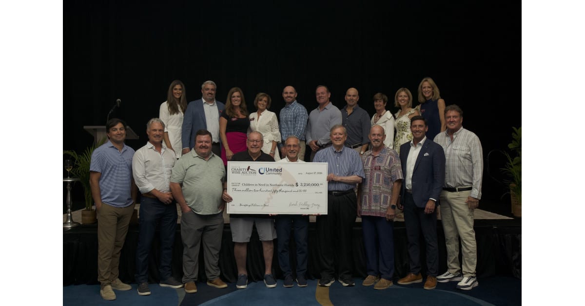 Community leaders celebrating with oversized ceremonial checks at charity grant presentation ceremony