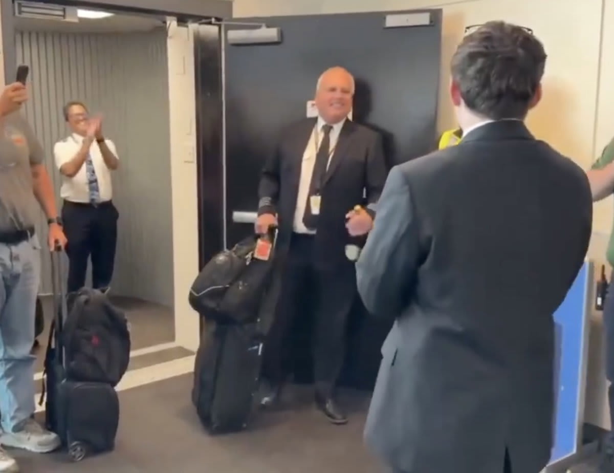 Southwest Airlines crew celebrating retiring Spirit Airlines Captain Jon Jackson at Baltimore airport gate