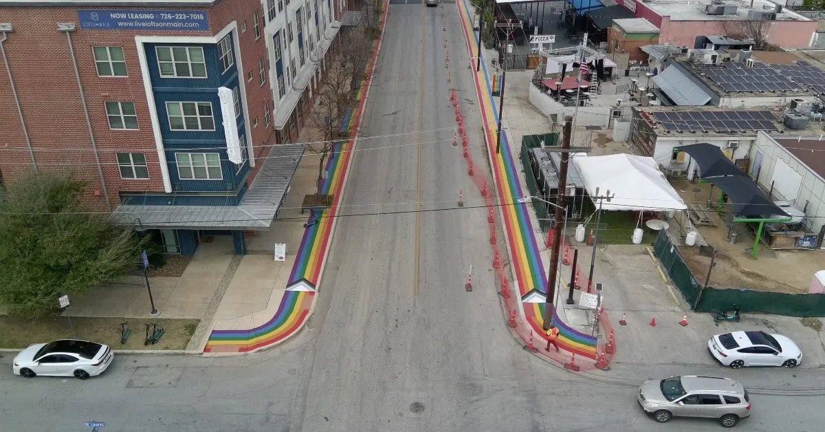 Aerial view of rainbow-painted sidewalks at San Antonio intersection in Pride district