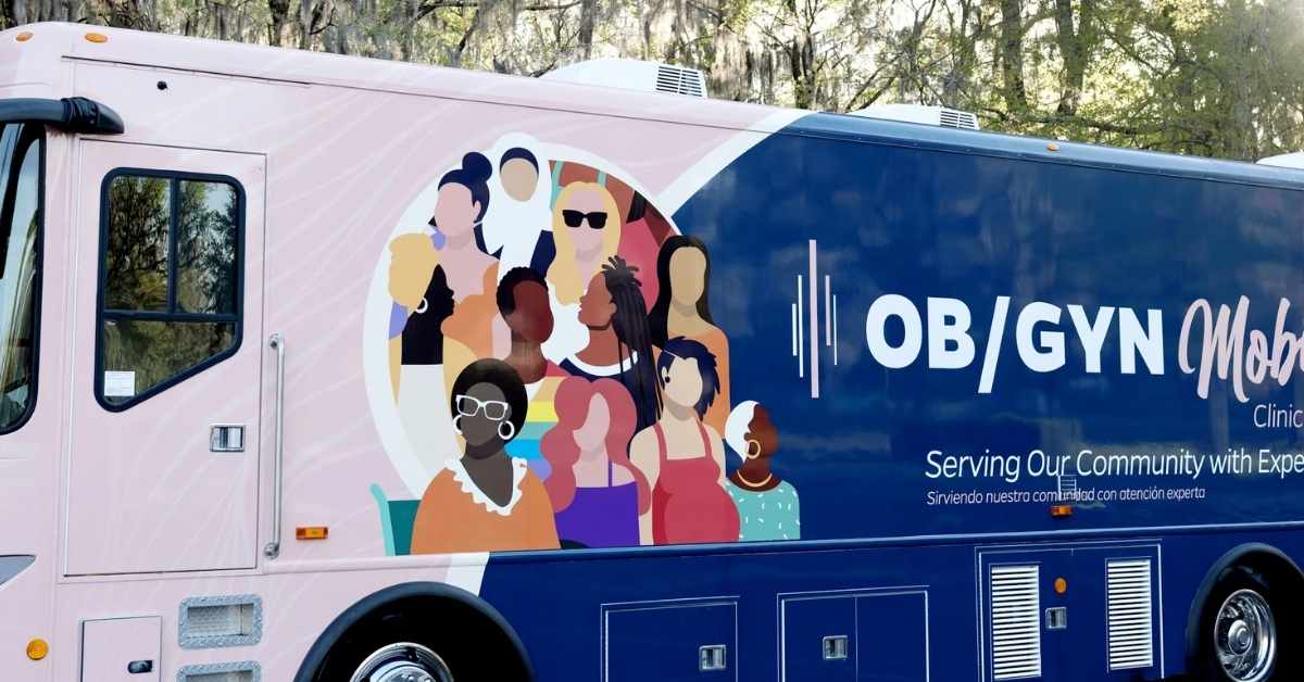 Mobile health clinic bus parked outside community building providing free maternal healthcare services