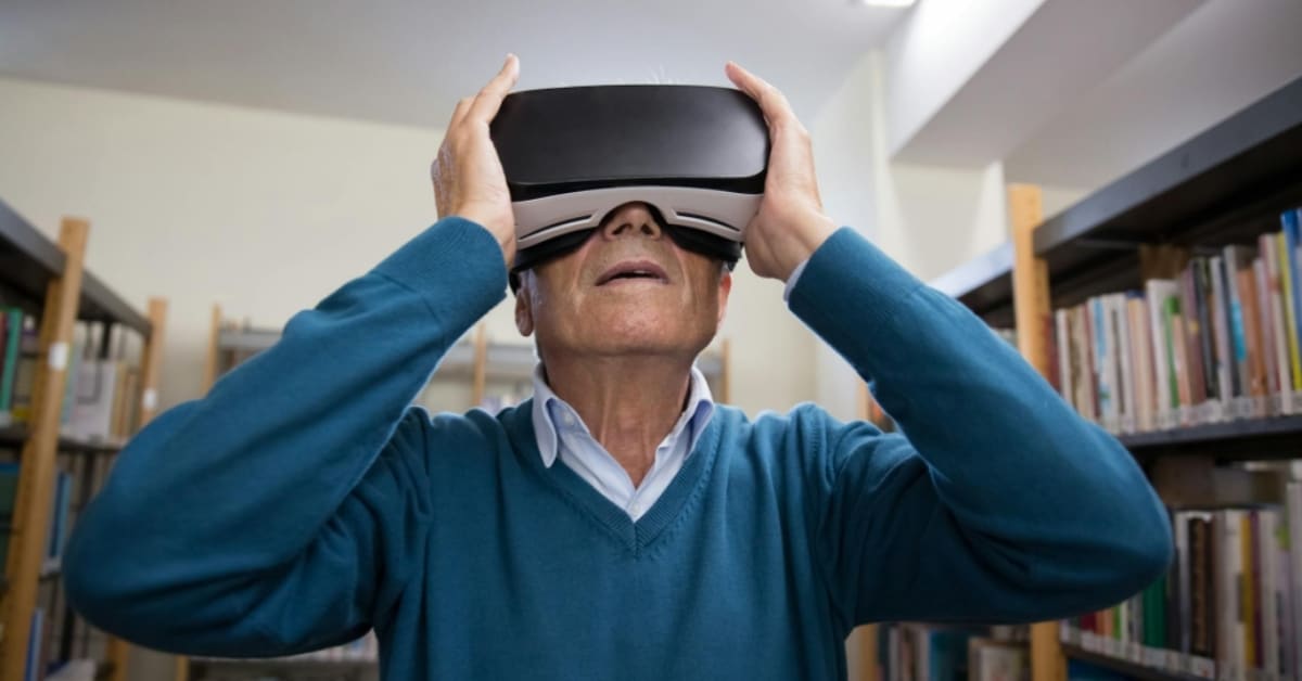 Older adult wearing virtual reality headset while seated, engaging with digital technology
