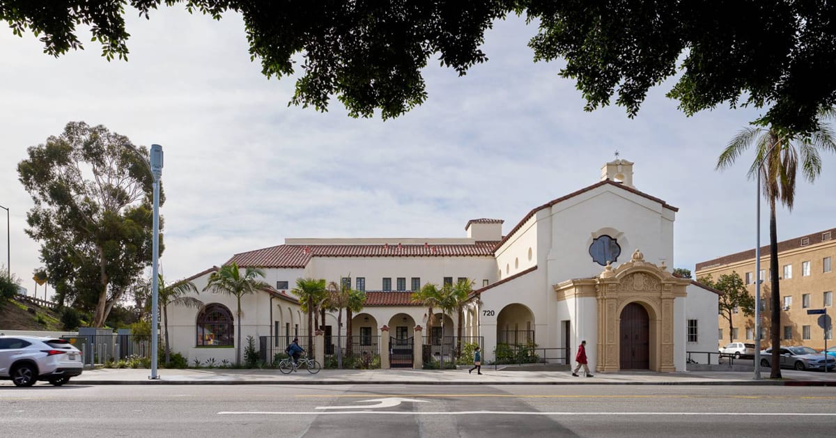 Historic Spanish Colonial building with red tile roof and bell tower, now Washington View Apartments