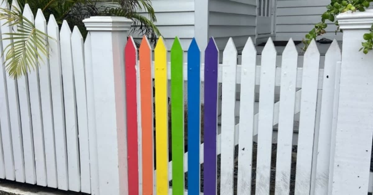 Rainbow colored picket fence in front of white house in Key West Florida