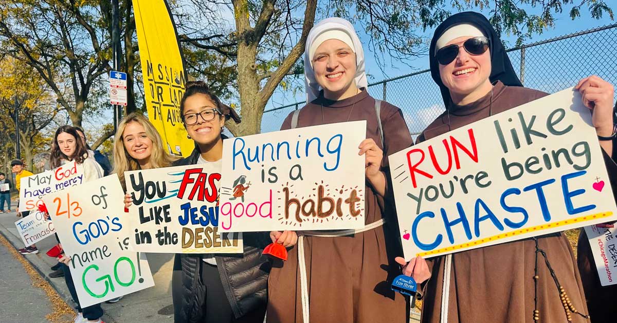 Sister Stephanie Baliga in running gear high-fiving supporters at Chicago marathon event