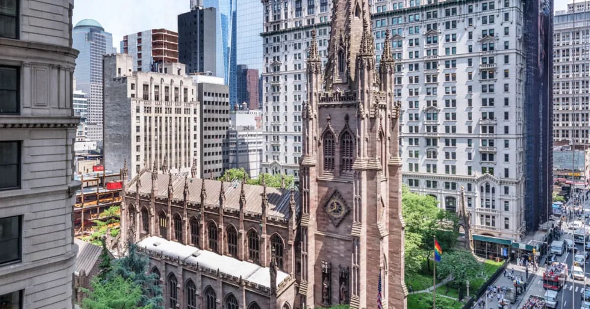 Historic Trinity Church tower in Lower Manhattan with One World Trade Center visible behind