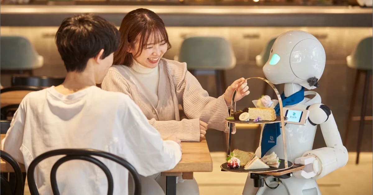 Green-eyed robot server at Dawn Avatar Robot Cafe controlled by remote disabled worker