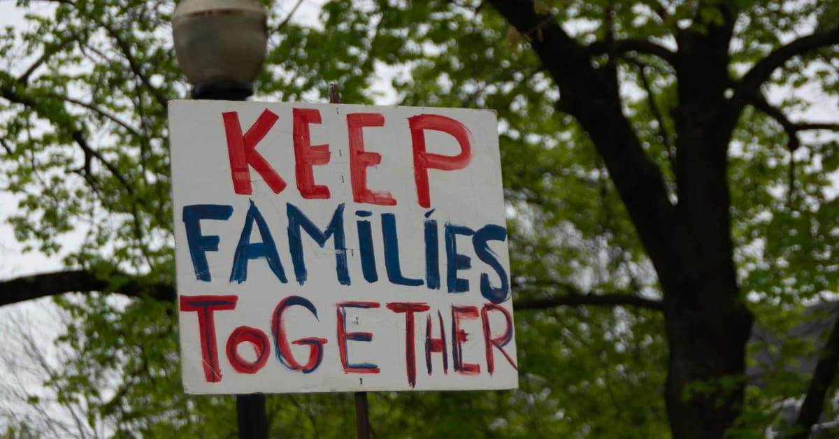 Community members gathering at prayer vigil holding candles in support of Haitian neighbors