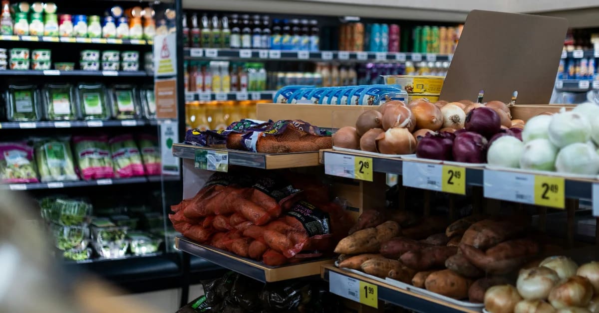 Grocery store aisle with electronic price tags and shoppers comparing products on shelves