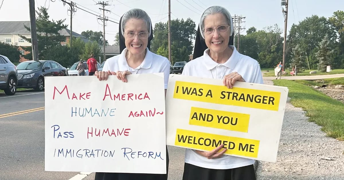 Catholic nuns holding handwritten signs supporting immigrant dignity outside ICE office in Blue Ash, Ohio