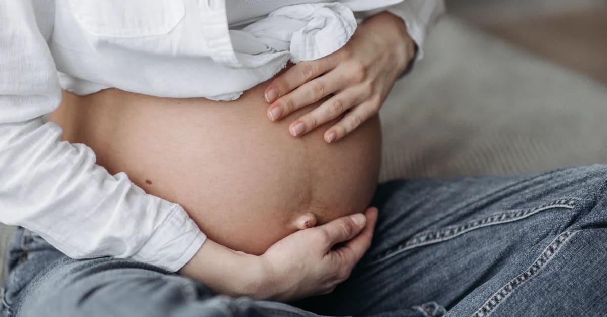 ** Pregnant woman receiving supportive care from doula during prenatal visit in medical setting