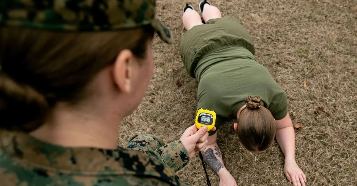 Female Marine in combat gear participates in physical fitness training exercise
